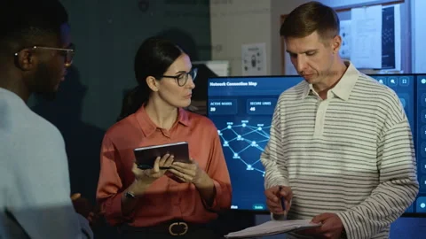 Diverse Cybersecurity Team Discussing Cybersecurity Data in Office Stock Footage 346815997