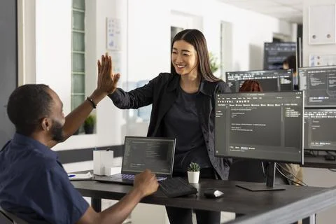 Diverse developers celebrating coding milestones together Stock-Fotos