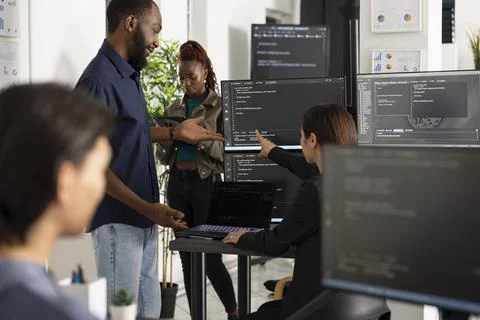 Diverse developers improving app functionality in modern office 写真素材