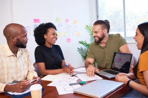 Diverse development team discusses code during code review meeting, programming Foto stock