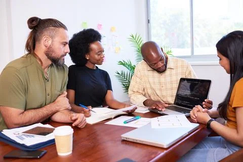 Diverse development team discusses code during code review meeting, programming Stock Photos