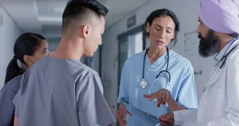 Diverse doctors and nurses talking in corridor at hospital, in slow motion Stock Footage 335129860