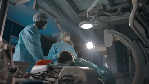 Diverse doctors examining screen during surgery Stock Footage 127198613
