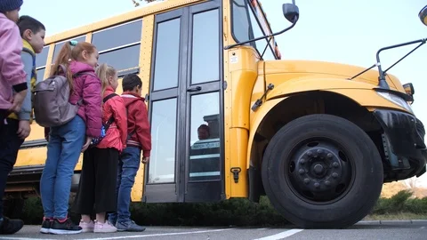 Diverse elementary age kids getting on school bus Stock Footage 122261632