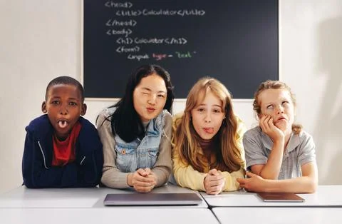 Diverse elementary school children making funny faces in a coding class Stock Photos