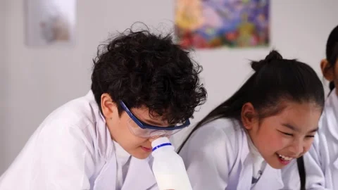 Diverse Elementary Students Conducting Science Experiment in Classroom Stock Footage 337923667