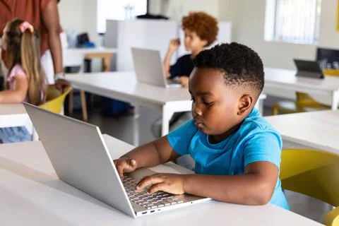 Diverse elementary students using laptops at school African American boy typing 스톡 사진