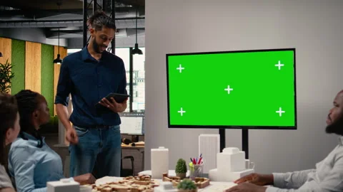 Diverse engineering staff study zoning regulations next to green screen on TV Stock Footage 316794995