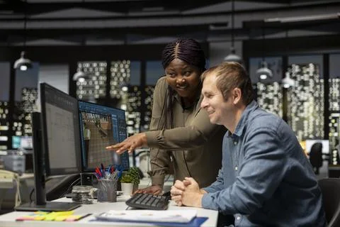 Diverse engineering team designing a floor plan on dual monitors Stock Photos