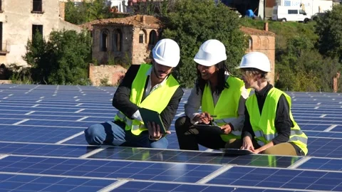 Diverse engineering team inspecting solar panels and using tablet Stock Footage 319982041