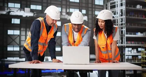 Diverse Engineering Team Using Laptop Screen At Rocket Manufacturing Facility Stock Photos