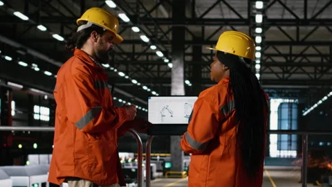 Diverse engineers analyzes robotics software for industrial component Stock Footage 330087395