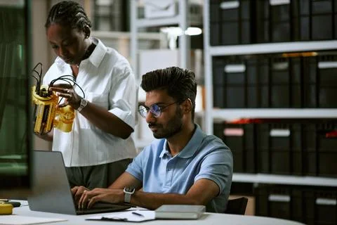 Diverse Engineers Developing Robotic Arm Prototype in Modern Laboratory Stock Photos