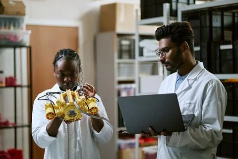 Diverse Engineers Testing Robotic Prototype in Laboratory Stock Photos