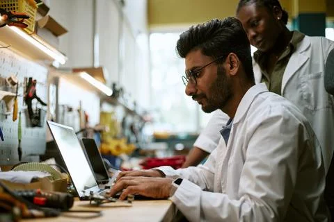 Diverse Engineers Working on Laptop in Robotics Laboratory 写真素材