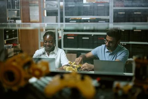 Diverse Engineers Working on Robotics Prototype with Laptops Stock Photos