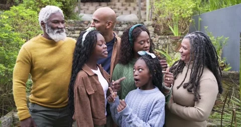 Diverse family assembling on stone steps in backyard posing for portrait Video stock 317659334