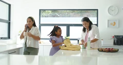 Diverse family packing yellow backpack for child in kitchen while mom offering Stock Footage 338326558