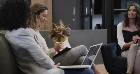 Diverse female colleagues in discussion using laptop and tablet in office Stock Footage 344849742
