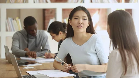 Diverse female college university students talking studying together in Stock Footage