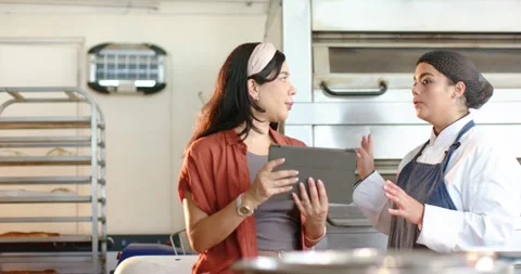 Diverse female coworkers checking tablet notes manager pointing tablet urging Stock Footage 336716465