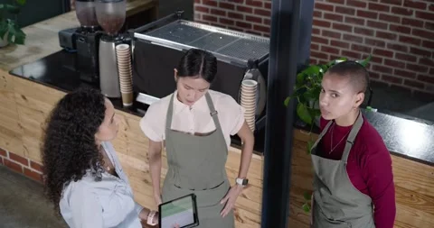 Diverse female crew watching manager pointing tablet, center taking it and Stock Footage 344671044