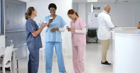 Diverse female doctors talking and drinking coffee at hospital, slow motion Stock Footage 336436248
