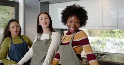 Diverse female friends camera rolling, filming recipe at kitchen island with Vídeo Stock 340655111