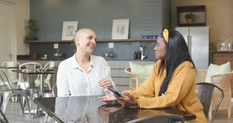 Diverse female friends hearing buzz and examining phone in kitchen, spurring Stock Footage 341932010