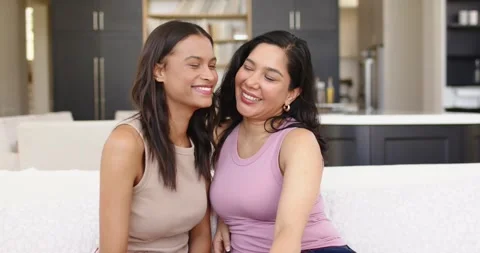 Diverse female friends posing for camera, relaxing into laughter, leaning on Stock Footage 340773637