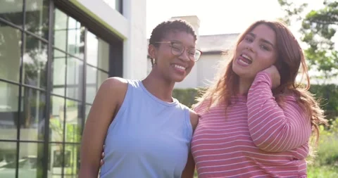 Diverse female friends posing outside home with grid windows, camera causing Stock Footage 338062851