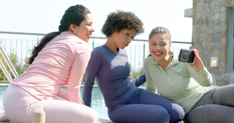 Diverse female friends pulling smartphone from pocket, angling it, capturing Stock Footage 335268939