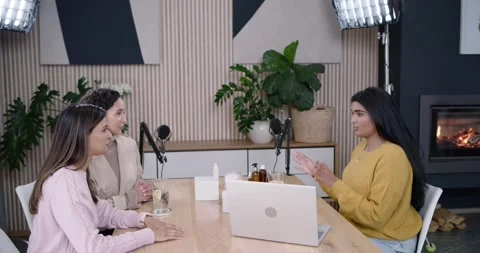 Diverse female hosts sitting at studio table during discussion, presenting white Stock Footage 344463505