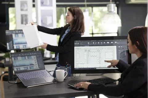 Diverse female professionals working with computer and 3d building model Stock Photos