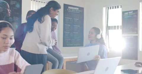 Diverse female students in lab leaning and gesturing, laptop user sharing screen Stock Footage 341063448