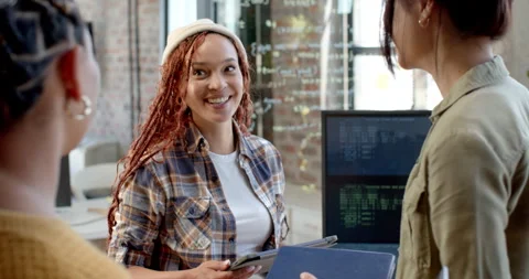 Diverse female team collaborating in modern office, discussing coding project Stock Footage 311495593