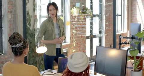 Diverse female team collaborating on software development project in modern Stock Footage 311495601