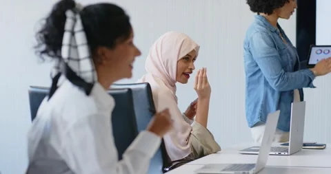 Diverse female team at table while presenter tapping tablet and Indian woman Stock Footage 346178247