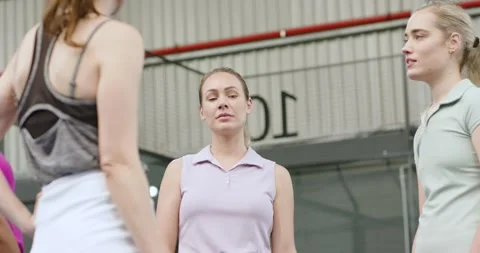 Diverse female teammates stepping forward, raising paddles, explaining serve on Stock Footage 343365736