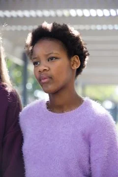 Diverse female teens posing under pergola, wearing fuzzy lavender sweater, Stock Photos