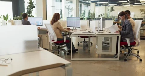 Diverse finance team analyzing data and reports at computers in modern office Stock Footage 344744074