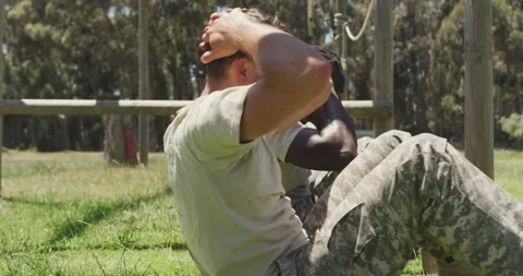 Diverse fit group of soldiers doing sit ups in field, at army obstacle course in Stock Footage 341239614