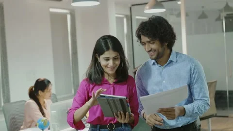 Diverse friendly co workers talking using digital tablet in office. Видео 168233467