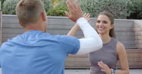 Diverse friends celebrating workout, man raising hand initiating high-five on Stock Footage 345124177