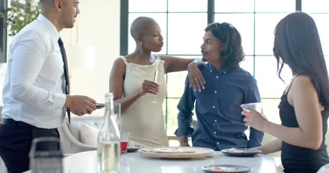 Diverse friends chatting at round table in bright room, woman in beige lifting Stock Footage 341467921
