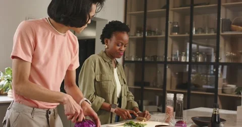 Diverse friends chopping cabbage, herbs at kitchen island, sparked by man Vidéo 345071031