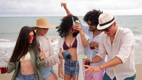 Diverse friends dancing drinking cocktails at beach party Stock Footage 335875284