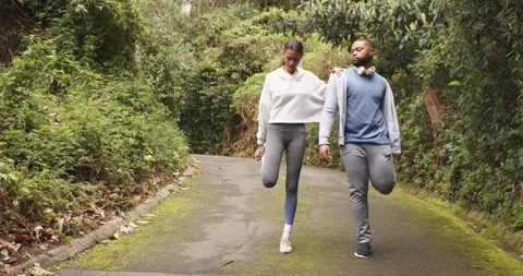 Diverse friends doing thigh stretch then shifting into knee lifts and stepping Stock Footage 341931892
