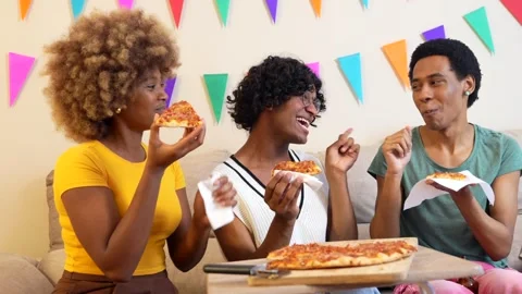 Diverse friends eating a slice of pizza at home Stock Footage 276895566