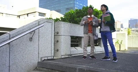 Diverse friends holding coffee noticing architecture, checking phone and Stock Footage 337096853
